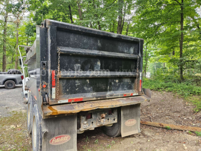 Dump truck bed of a Peterbilt 335 rear view showing dump body and mud flaps.