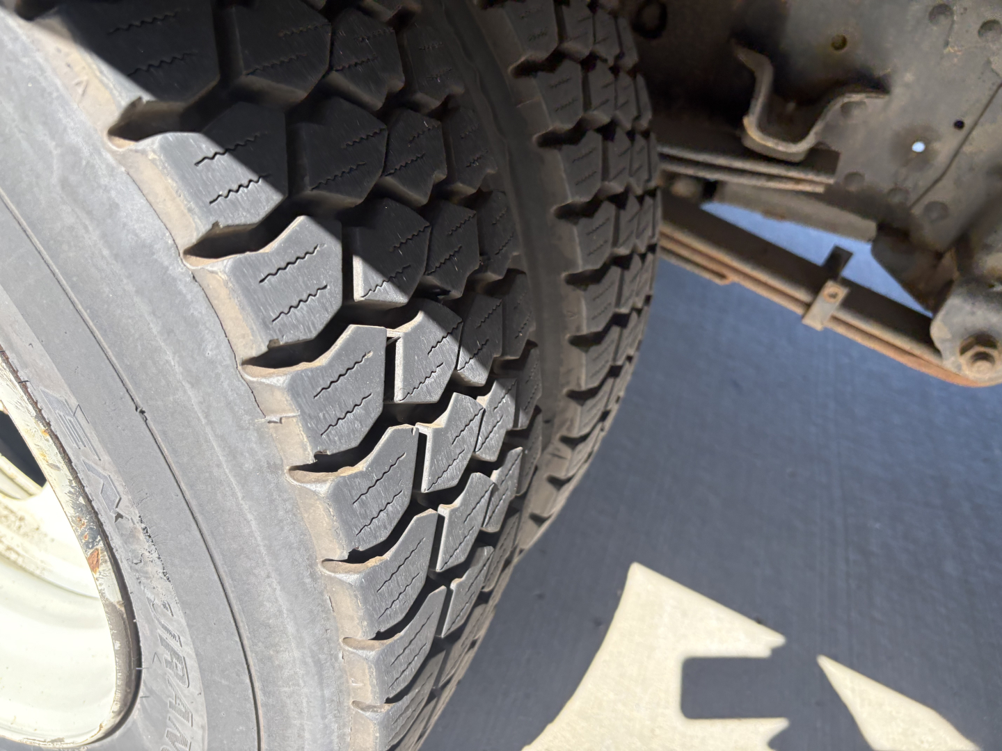 Truck wheel and tire with undercarriage view in a refrigerated 2020 Chevrolet W4500 listing.