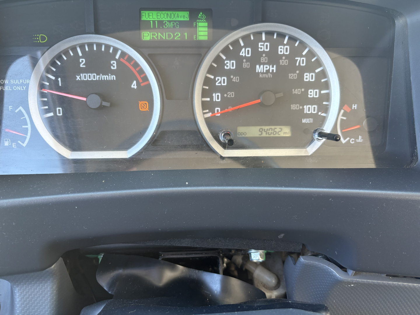Dashboard gauges of a 2020 Chevrolet W4500 showing tachometer, speedometer, and various indicator displays. Center digital screen shows PRND21 gear indicator and icons; left gauge shows 0-7000 RPM, right gauge shows 0-100 MPH.