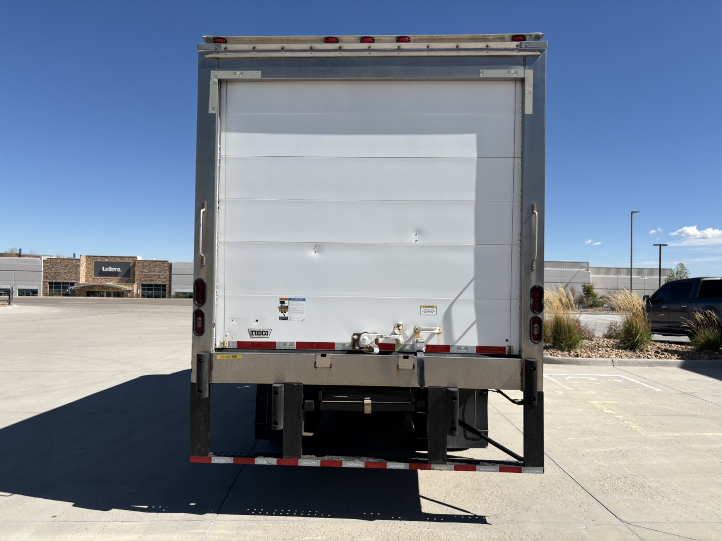 Truck rear view of 2020 Chevrolet W4500 refrigerated box truck showing rear doors and bumper with reflective tape.
