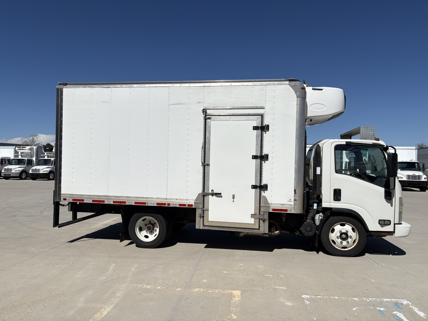 White refrigerated box truck side view showing cargo body with rear access door and cab in front, Chevrolet W4500 utility truck.
