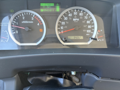 Dashboard gauges of a 2020 Chevrolet W4500 showing tachometer, speedometer, and various indicator displays. Center digital screen shows PRND21 gear indicator and icons; left gauge shows 0-7000 RPM, right gauge shows 0-100 MPH.