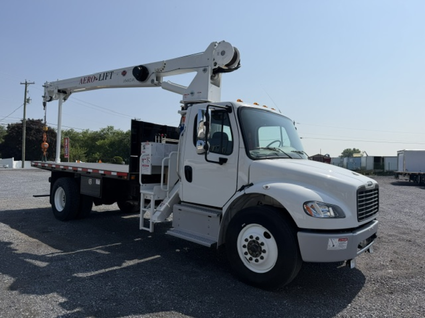 Freightliner M2-106 bucket crane truck side view showing crane boom labeled 'HERB-LIFT' and crane platform