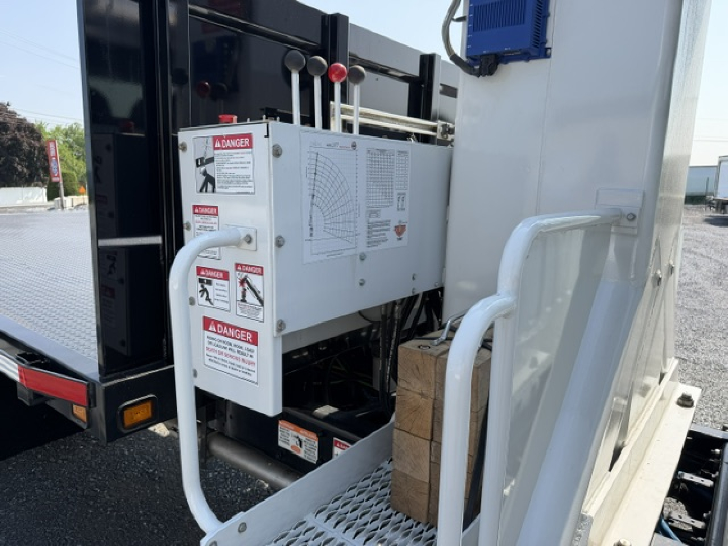 Freightliner M2-106 crane truck side panel with control box and warning labels visible.