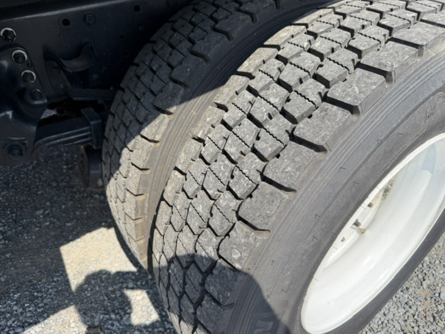 Truck wheel and tire close-up showing heavy-duty dual rear axle with tread pattern