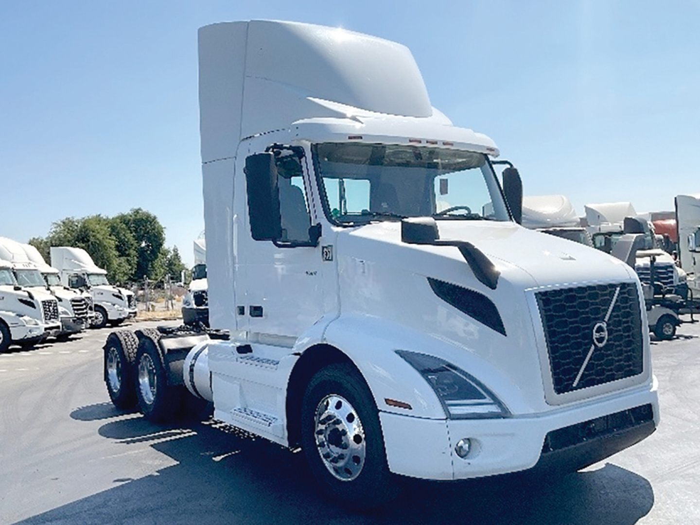 Volvo VNR 300 tractor in hub showing side cab and front grille with Volvo emblem and daytime cab sleeper behind.