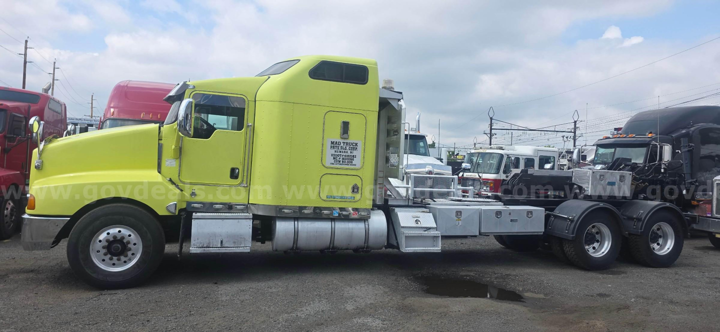 Kenworth T600 tractor in lime green color, side view showing cab with sleeper, chrome fuel tanks, and attached trailer chassis; VIN 1XKADB9X7TJ683080 visible on listing.