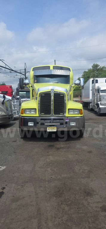 Kenworth T600 truck front view showing bright green exterior and grille, headlights, and front bumper.