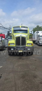 Kenworth T600 truck front view showing bright green exterior and grille, headlights, and front bumper.