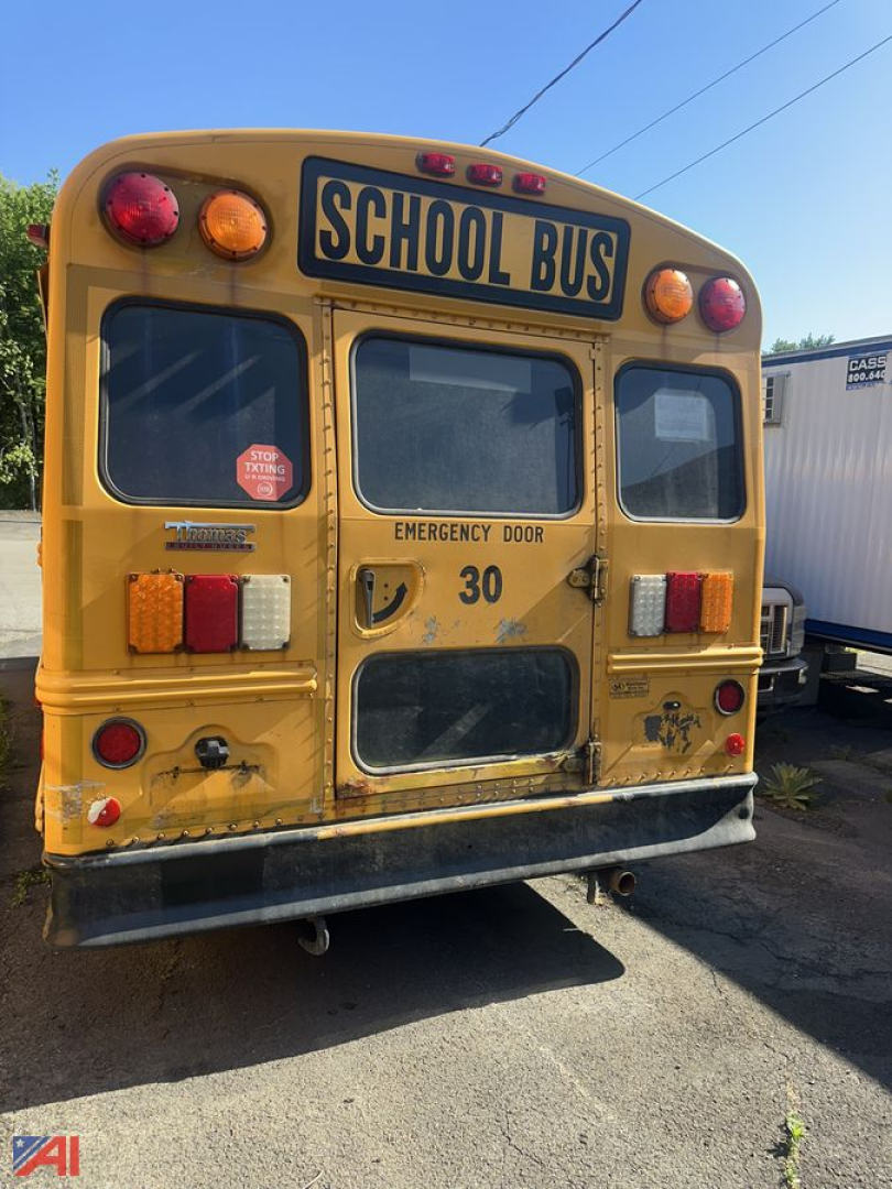 Rear view of a yellow school bus with 'SCHOOL BUS' sign, emergency door, and stop sign lights; number 30 on door, various lights and reflective markers.
