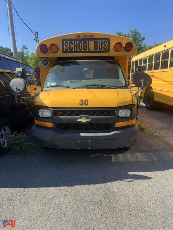 Bus front view showing Chevrolet Express school bus with yellow paint, number 30 on hood, and School Bus sign above windshield