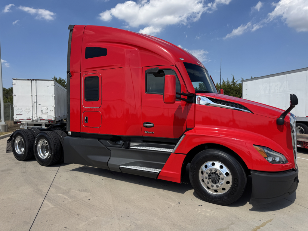 Kenworth T680 sleeper cab truck in red, side view, with three rear axles and chrome wheels.