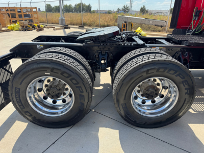 Kenworth T680 tractor frame with dual rear axles and dual tires showing Goodyear tires and chrome wheels.