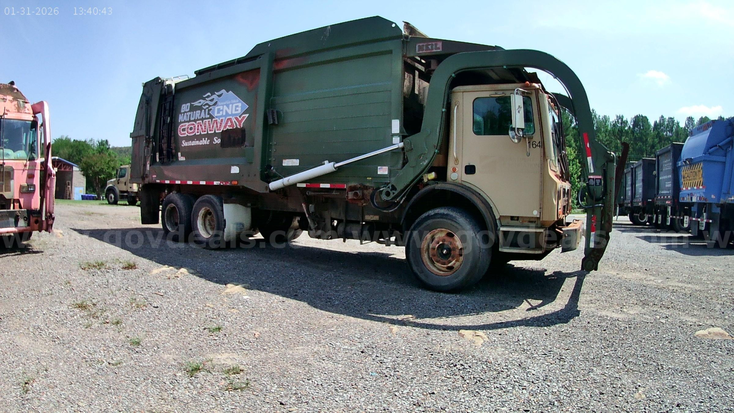 Garbage truck 2015 Mack MRU613 side view with cab and rear compactor, VIN sticker not readable, stock number 9953-398 visible in listing, front wheel visible.