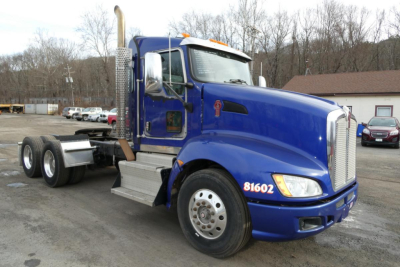 Kenworth T660 tractor-trailer in blue, front three-quarter view showing cab and wheel setup with chrome exhaust stack, VIN/stock notations absent