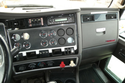 Kenworth T660 dash panel showing gauges, switches, and radio in-cab view.
