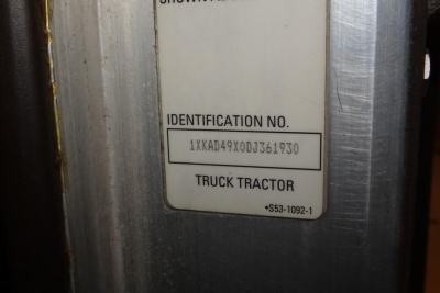 Identification plate showing VIN-like text and label 'IDENTIFICATION NO.' with alphanumeric string 1XKAD49X0DJ361930 and 'TRUCK TRACTOR' area.