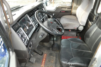 Kenworth T660 cab interior showing steering wheel dashboard gauges and driver seat