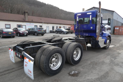 Kenworth T660 truck chassis with dual rear axles and blue cab, rear view showing frame and tires.