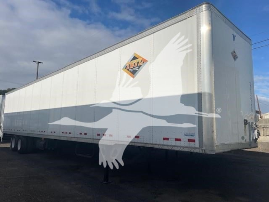 Trailer side view showing a white Vanguard VXP cargo trailer with logo and support legs visible.
