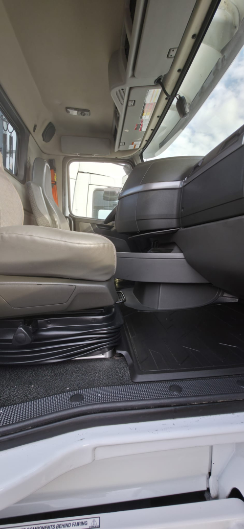 Cab interior of a 2019 Hino 155 box truck showing the driver seat, step and entry area with dashboard and sun visor.