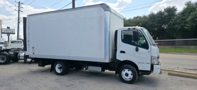 2019 Hino 155 box truck in service showing cargo box and cab with blue-gray exterior. Side view reveals box area and front bumper.