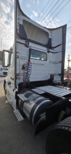 Truck cab rear with raised sleeper door and coiled air hoses; Hino 155 tag visible on window area.