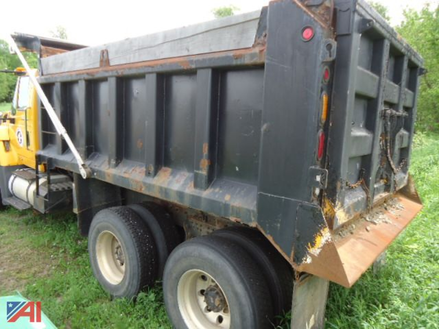 Dump truck bed of a 2008 International WorkStar 7600 dump truck showing worn metal sides and rear tailgate.