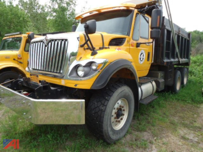 Dump truck showing International WorkStar 7600 front and passenger side view with chrome bumper and yellow cab.