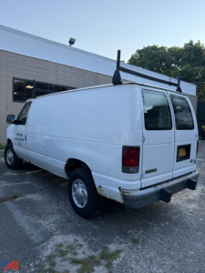 Cargo van side and rear view showing plain white 2006 Ford E250 with no window on side, rear doors, and visible damage at bumper.
