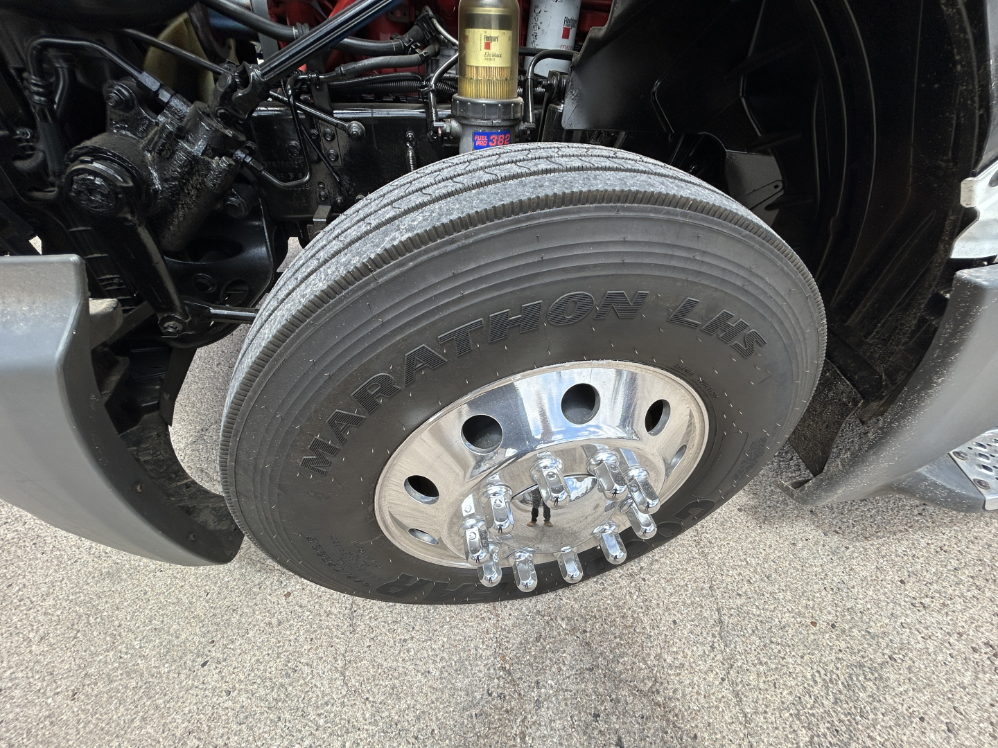 Front wheel and suspension of a 2021 International LT625 conventional daycab showing large Manatom LHF tire and wheel components.