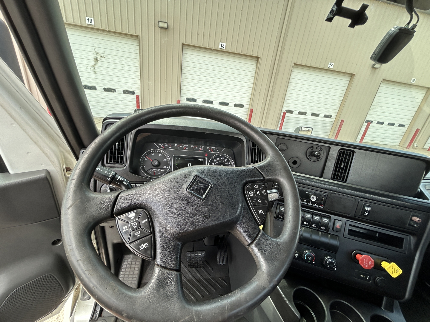Steering wheel and instrument cluster of a 2021 International LT625 daycab truck interior with dashboard controls visible.