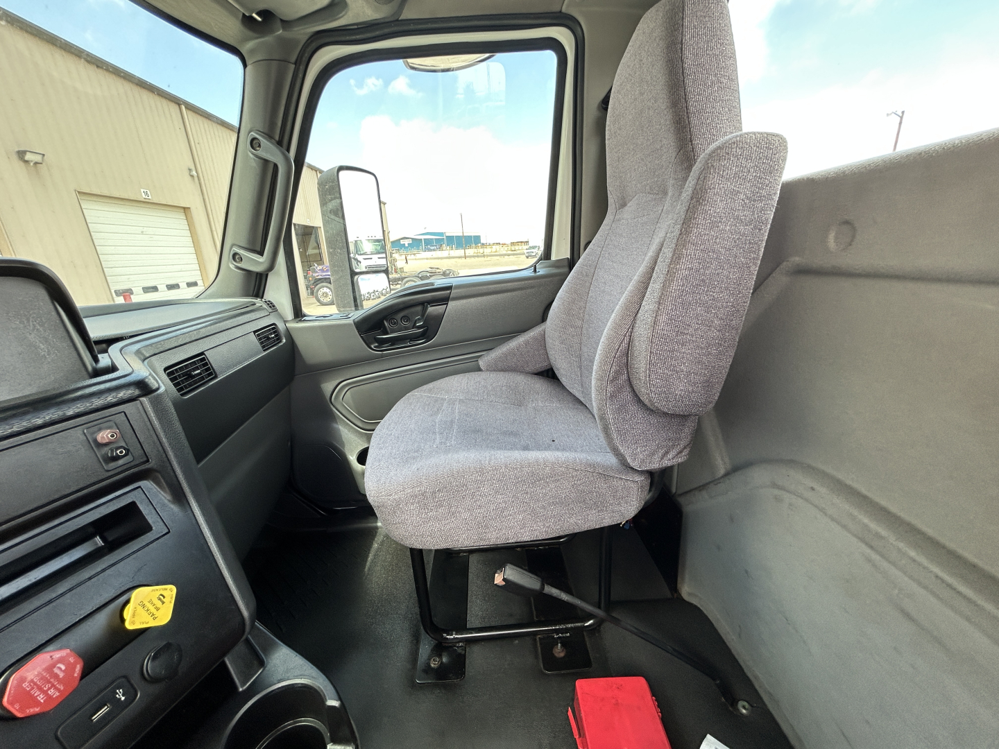 Cab interior of a 2021 International LT625 daycab truck showing Driver seat and dashboard with window view outside.