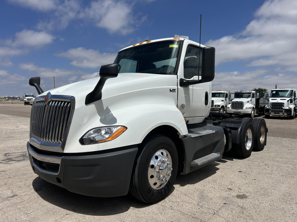 International LT625 truck cab and chassis, white exterior, front left view with dual rear axles, badge and mirrors visible.
