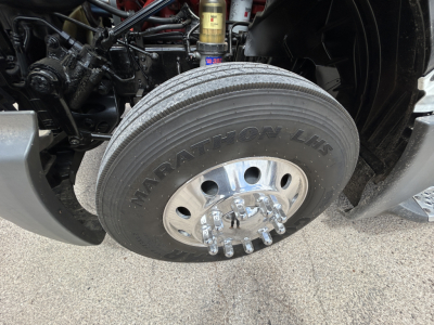 Front wheel and suspension of a 2021 International LT625 conventional daycab showing large Manatom LHF tire and wheel components.