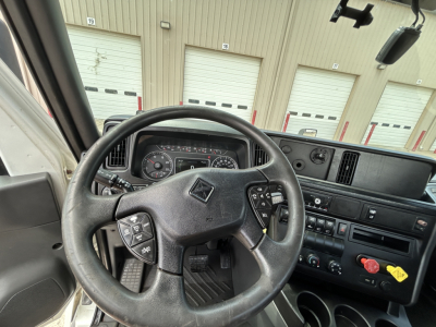 Steering wheel and instrument cluster of a 2021 International LT625 daycab truck interior with dashboard controls visible.