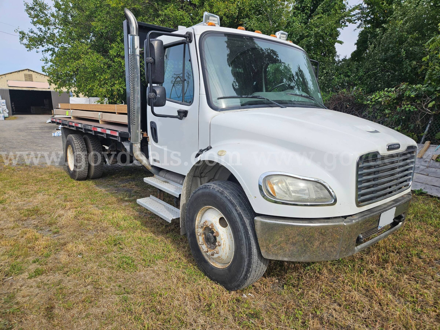 Freightliner M2 106 dump truck in white, front three-quarter view, with flatbed and dual rear wheels, stock number 32136-92 visible on image watermark