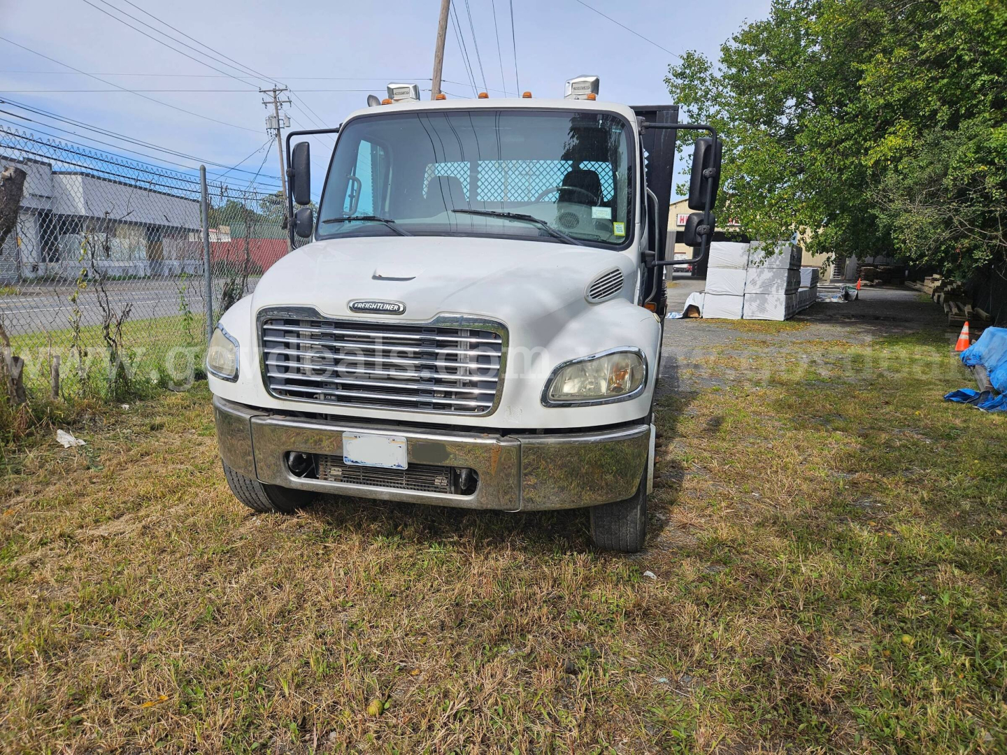 Front view of a white 2004 Freightliner M2 106 dump truck showing grille, headlights, and bumper