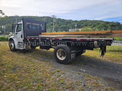 Dump truck bed of a 2004 Freightliner M2 106 with flatbed and metal side rails, white cab, single rear wheel, and frame-mounted utility area.