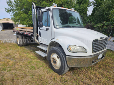 Freightliner M2 106 dump truck in white, front three-quarter view, with flatbed and dual rear wheels, stock number 32136-92 visible on image watermark