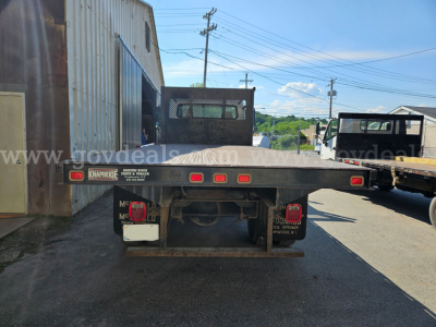 Freightliner M2 106 rear view showing flatbed with taillights and bumper, available in-service, stock number 32136-92, VIN 1FVACXAK44HM56681.