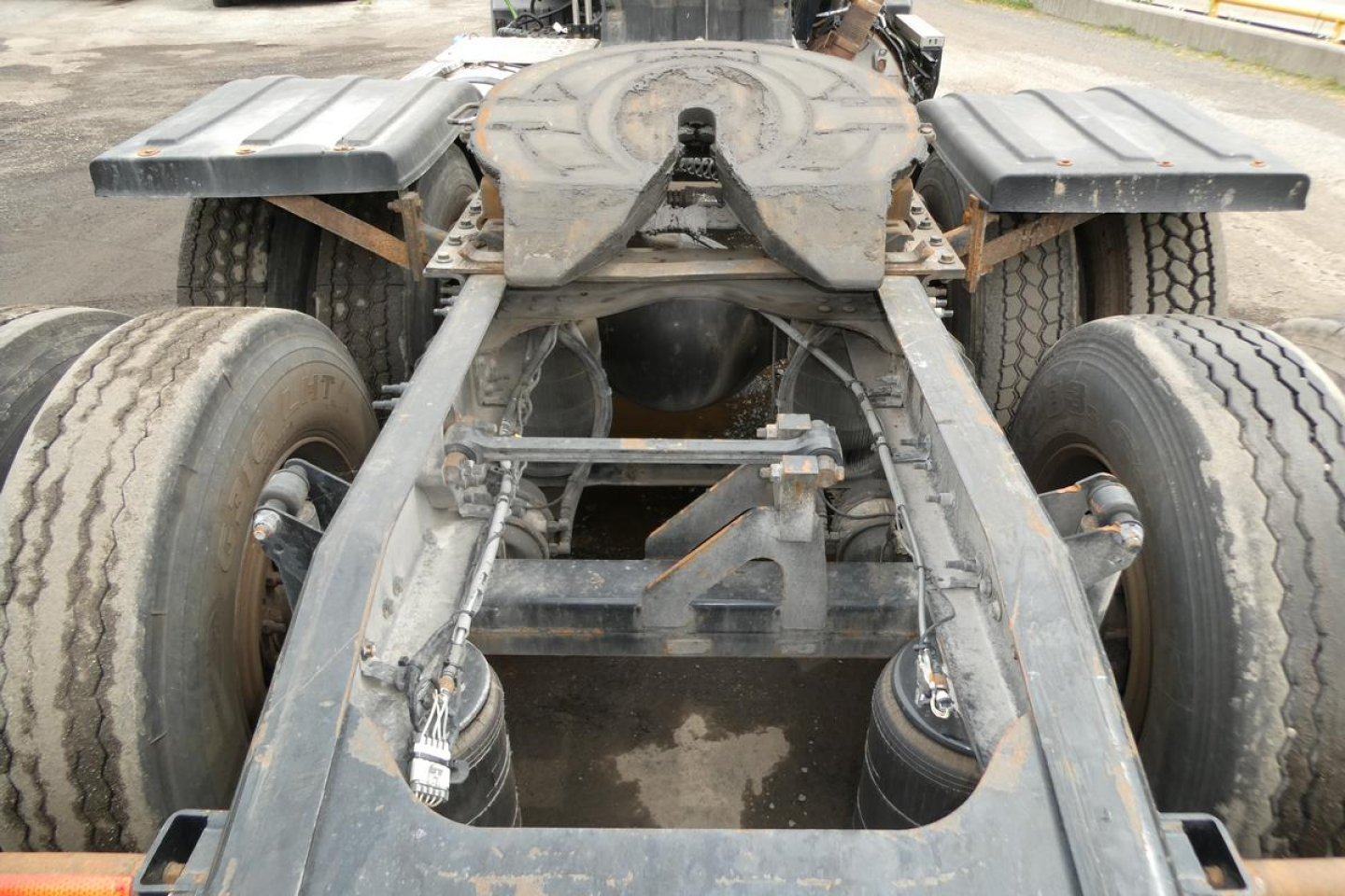 Frame and rear chassis of a 2018 Mack CXU613T truck showing chassis rails, dual rear axles, and seventh wheel area.