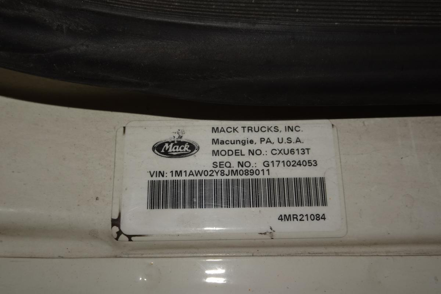 Mack Trucks label on door jamb showing MODEL NO: CXU613T and VIN 1M1AW02Y8JM089011 with barcode.