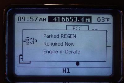 Cab display screen showing time, mileage 416,653.4 mi, outside temperature 63°F, and engine fault notices: Parked REGEN, Required Now, Engine in Derate.