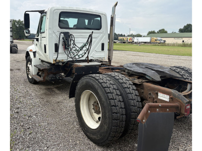 Truck chassis and cab of a 2007 International 4400 daycab showing rear view of fifth wheel area and dual rear tires.