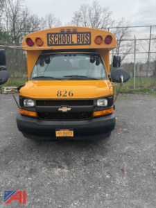 School bus front view showing bright yellow body, number 826 on hood, Chevrolet emblem, and 'SCHOOL BUS' sign above windshield.