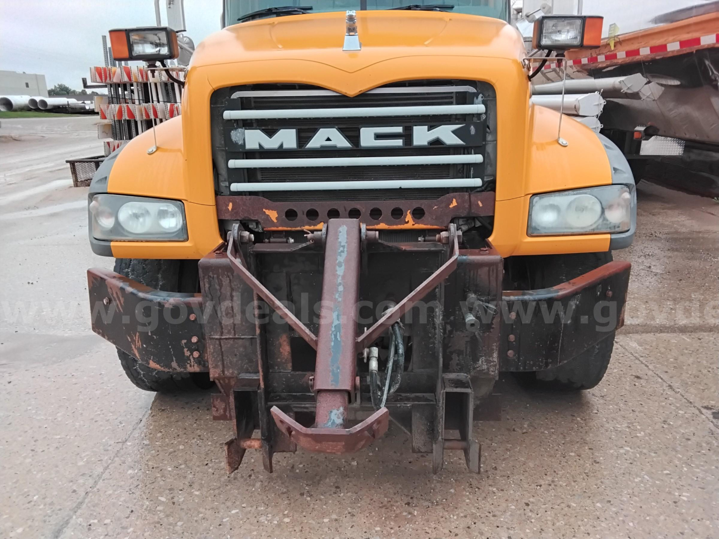 Mack GU dump truck front view showing large grille with MACK branding and front hitch assembly.