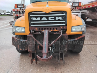 Mack GU dump truck front view showing large grille with MACK branding and front hitch assembly.