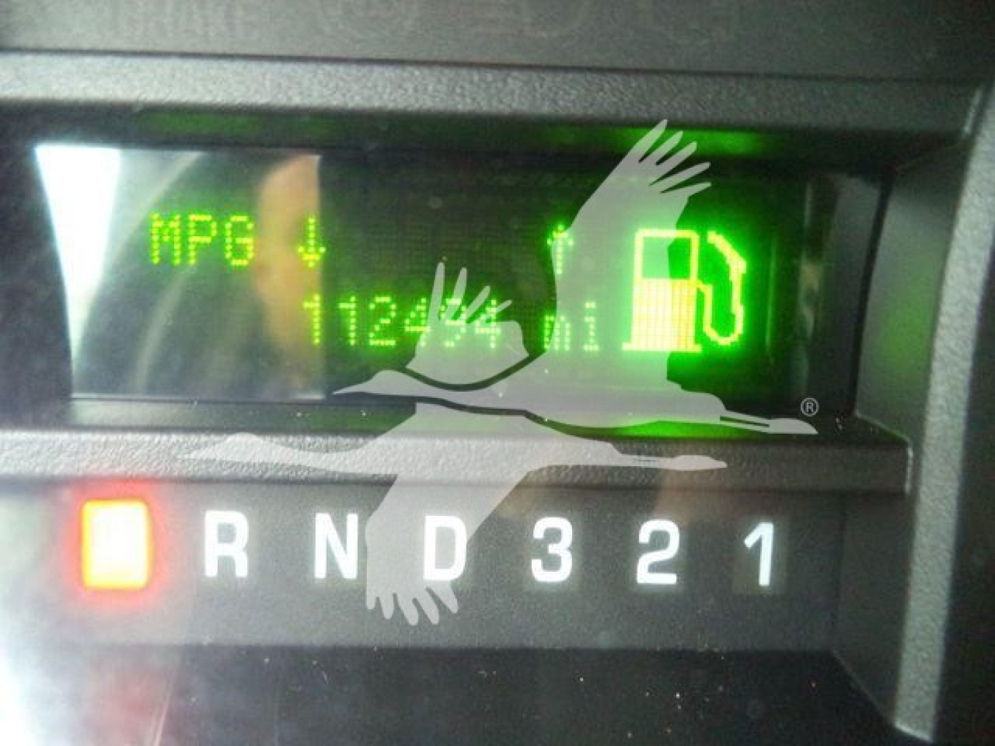 Dashboard view of a 2011 Ford E450 with gear selector showing R N D 3 2 1 and a green fuel gauge/readout on the instrument cluster.