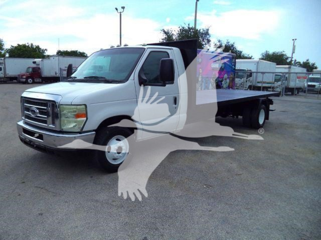 Flatbed tow truck 2011 Ford E450 in a used inventory lot, white cab and flatbed visible, stock # T07531FM.
